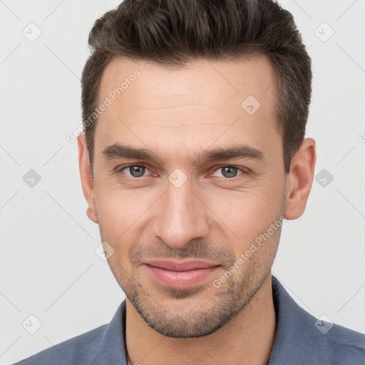 Joyful white young-adult male with short  brown hair and brown eyes