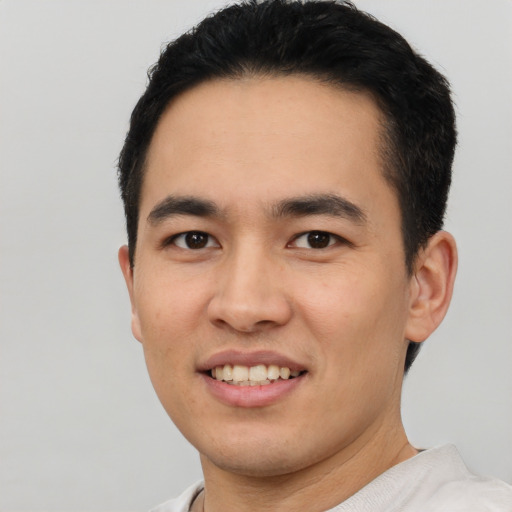 Joyful white young-adult male with short  black hair and brown eyes