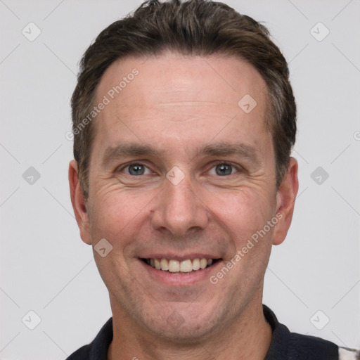 Joyful white adult male with short  brown hair and grey eyes