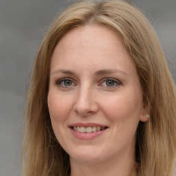 Joyful white adult female with long  brown hair and brown eyes