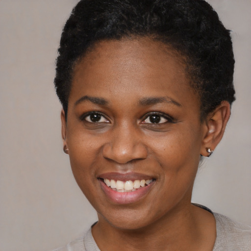 Joyful black young-adult female with short  black hair and brown eyes