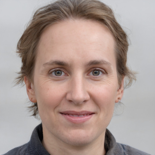 Joyful white adult female with medium  brown hair and grey eyes