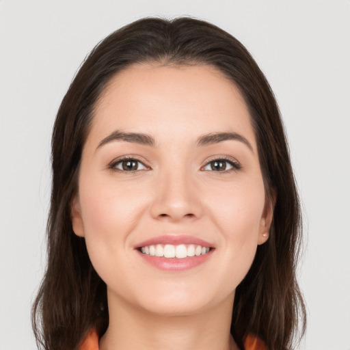 Joyful white young-adult female with long  brown hair and brown eyes