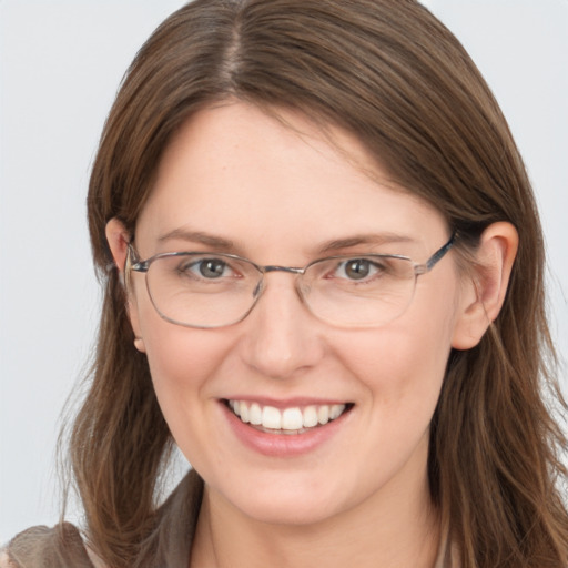 Joyful white adult female with long  brown hair and grey eyes