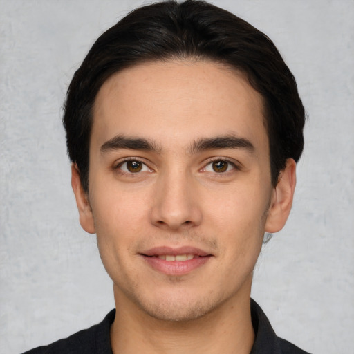 Joyful white young-adult male with short  black hair and brown eyes