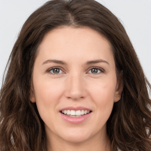 Joyful white young-adult female with long  brown hair and brown eyes