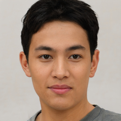 Joyful asian young-adult male with short  black hair and brown eyes