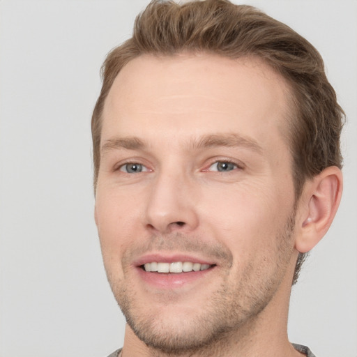 Joyful white adult male with short  brown hair and grey eyes