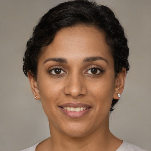 Joyful black young-adult female with short  brown hair and brown eyes