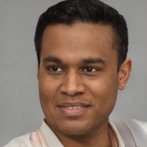 Joyful latino young-adult male with short  black hair and brown eyes