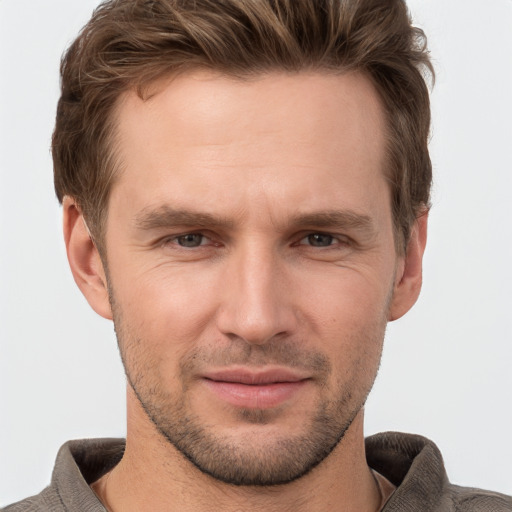 Joyful white young-adult male with short  brown hair and grey eyes