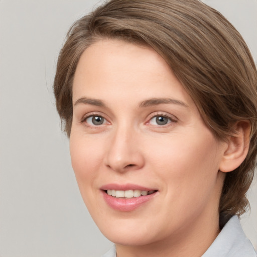 Joyful white young-adult female with medium  brown hair and grey eyes