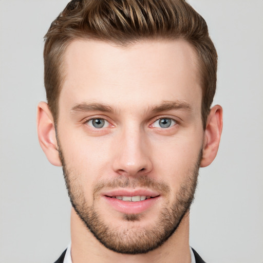 Joyful white young-adult male with short  brown hair and grey eyes