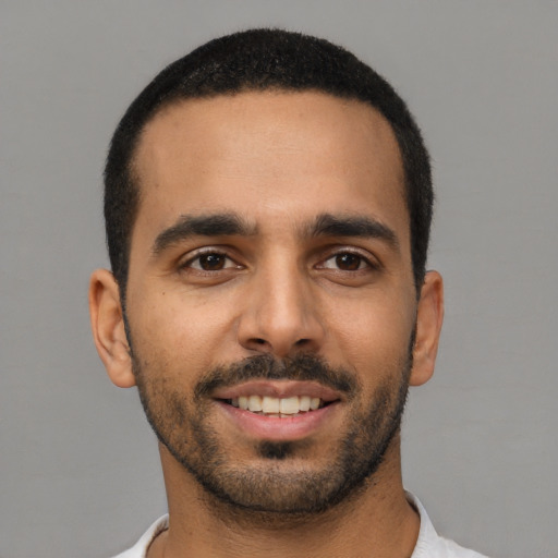Joyful latino young-adult male with short  black hair and brown eyes