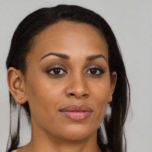 Joyful black young-adult female with long  brown hair and brown eyes