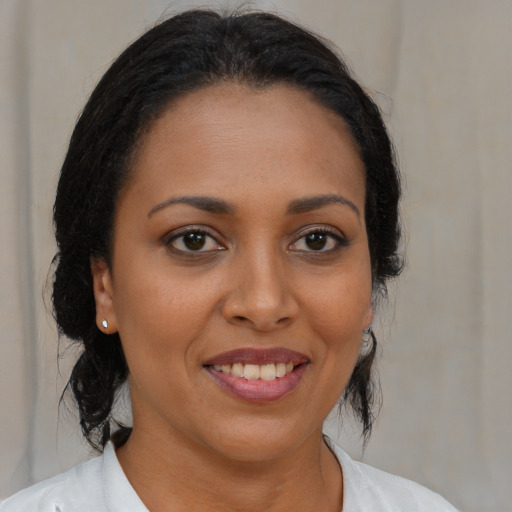 Joyful black young-adult female with medium  brown hair and brown eyes