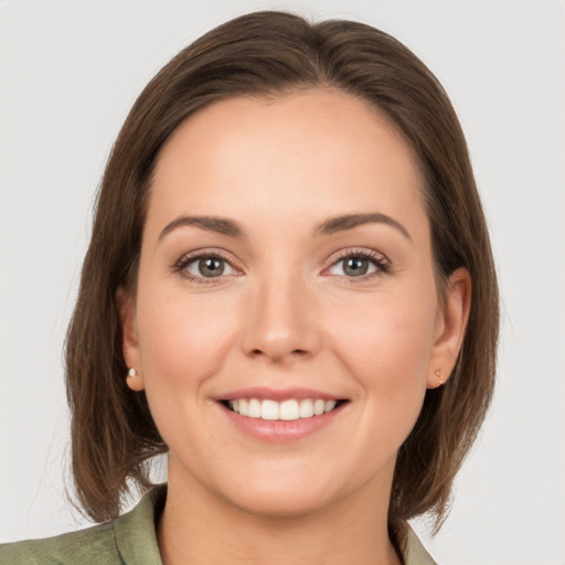 Joyful white young-adult female with medium  brown hair and grey eyes