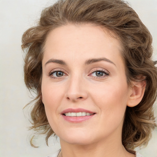 Joyful white young-adult female with medium  brown hair and green eyes