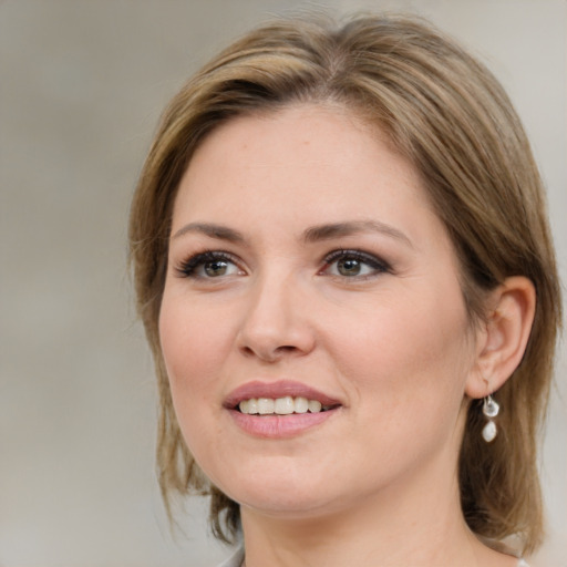 Joyful white young-adult female with medium  brown hair and green eyes