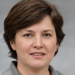 Joyful white adult female with medium  brown hair and grey eyes