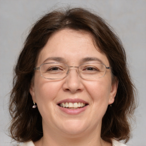 Joyful white adult female with medium  brown hair and grey eyes