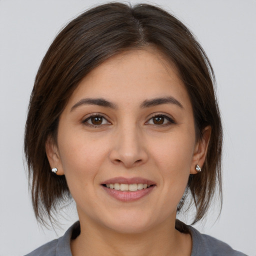 Joyful white young-adult female with medium  brown hair and brown eyes