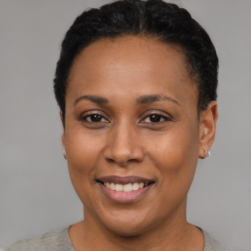 Joyful black adult female with short  black hair and brown eyes
