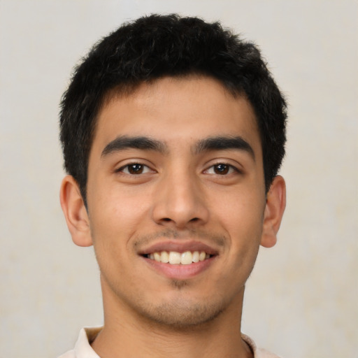 Joyful latino young-adult male with short  brown hair and brown eyes