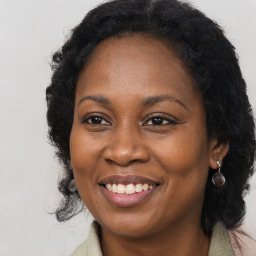 Joyful black adult female with long  brown hair and brown eyes