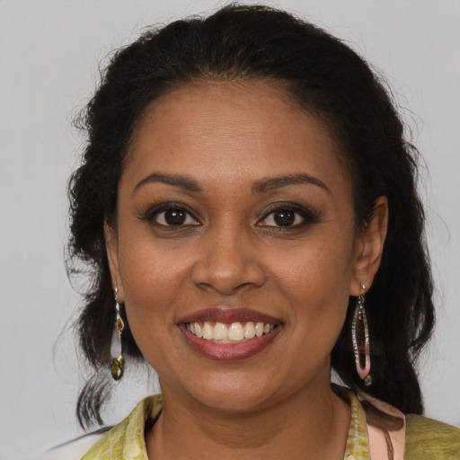 Joyful black young-adult female with long  brown hair and brown eyes