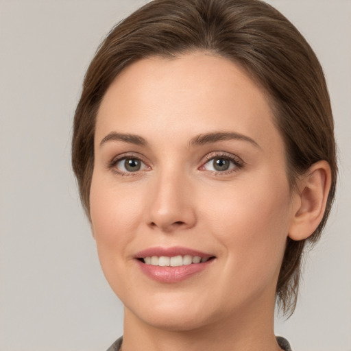 Joyful white young-adult female with medium  brown hair and grey eyes