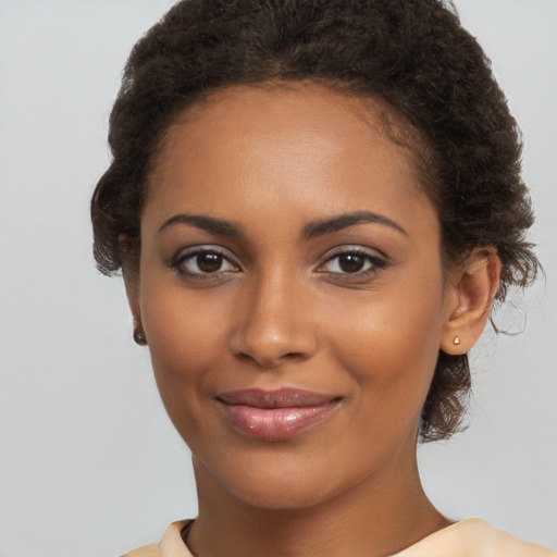 Joyful black young-adult female with medium  brown hair and brown eyes