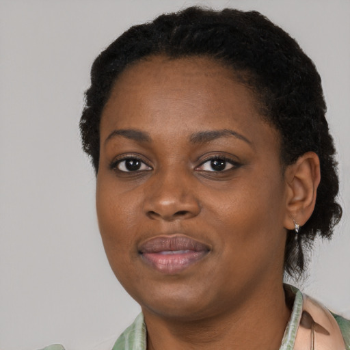 Joyful black young-adult female with short  black hair and brown eyes