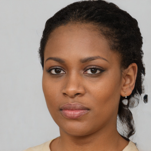 Joyful black young-adult female with medium  black hair and brown eyes