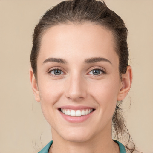 Joyful white young-adult female with long  brown hair and grey eyes