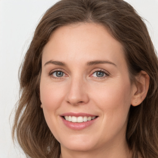 Joyful white young-adult female with long  brown hair and grey eyes