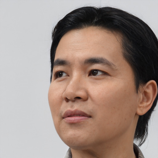 Joyful asian young-adult male with medium  black hair and brown eyes