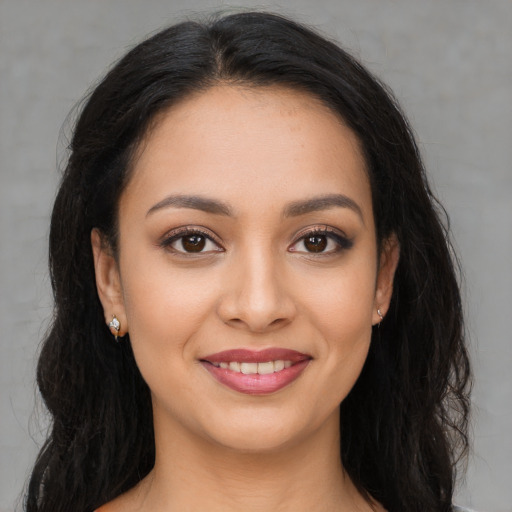 Joyful latino young-adult female with long  brown hair and brown eyes