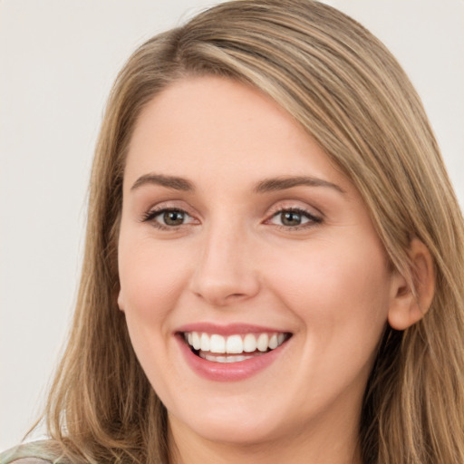 Joyful white young-adult female with long  brown hair and green eyes