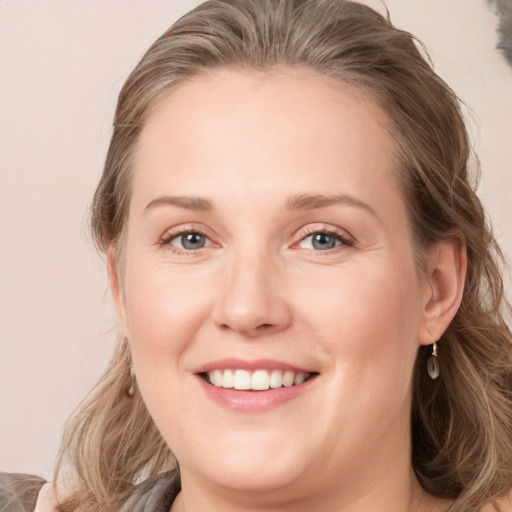 Joyful white young-adult female with medium  brown hair and blue eyes