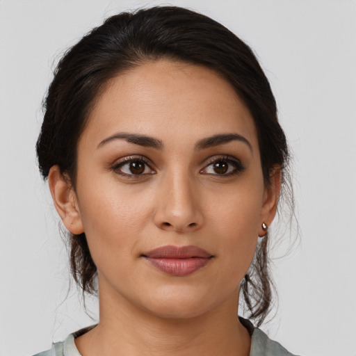 Joyful latino young-adult female with medium  brown hair and brown eyes
