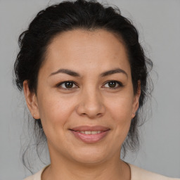 Joyful latino adult female with medium  brown hair and brown eyes