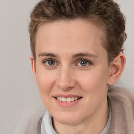 Joyful white young-adult female with short  brown hair and grey eyes