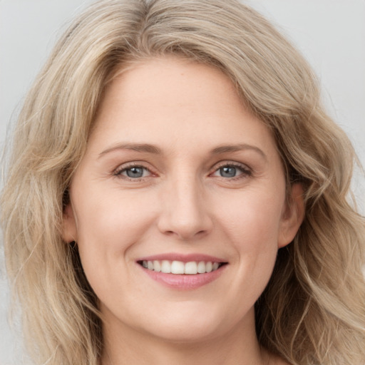 Joyful white young-adult female with long  brown hair and blue eyes