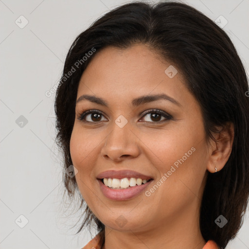 Joyful latino young-adult female with long  brown hair and brown eyes