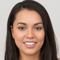 Joyful latino young-adult female with long  brown hair and brown eyes