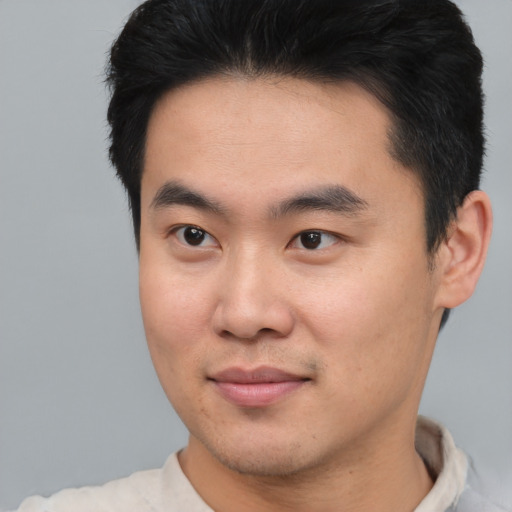 Joyful asian young-adult male with short  brown hair and brown eyes