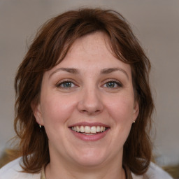 Joyful white young-adult female with medium  brown hair and blue eyes