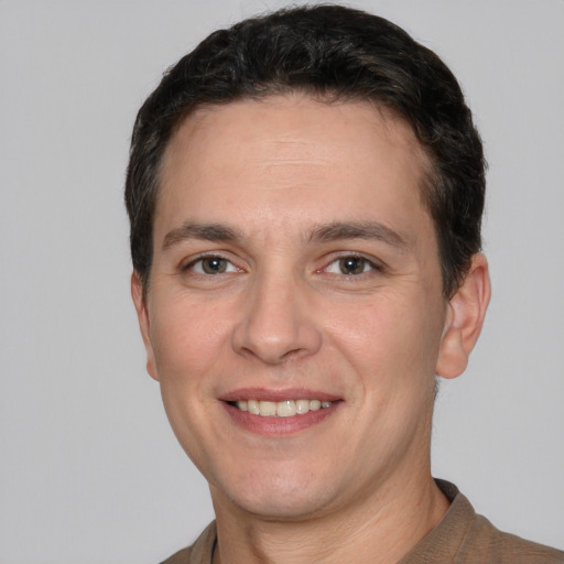 Joyful white adult male with short  brown hair and brown eyes