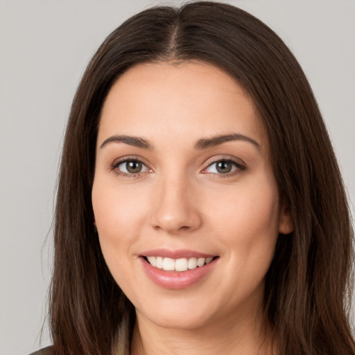 Joyful white young-adult female with long  brown hair and brown eyes